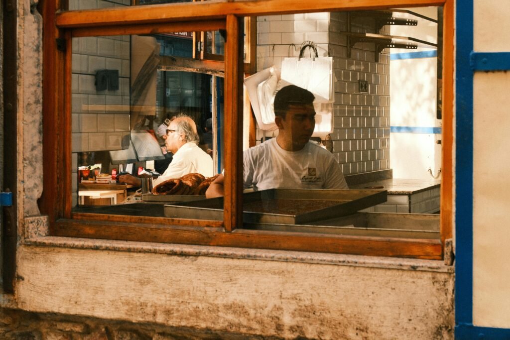 Street view through a bakery window in İzmir, showcasing everyday life and local culture.
